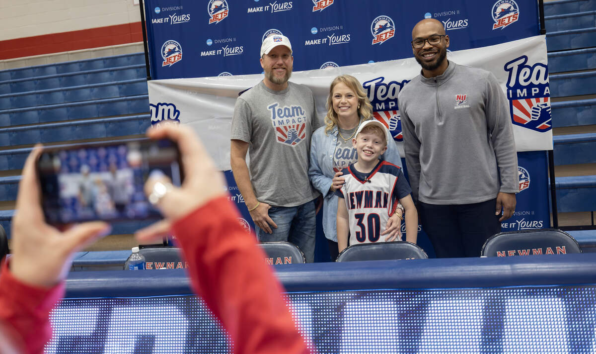 Ryker Ammons, 10, poses for photos with his parents, Ryan and Shawna, and Newman basketball coach R.J. Allen, after Ryker signed his letter of intent to become an honorary member of the Newman Jets’ basketball team on Thursday. The signing event was organized by Team IMPACT, a national nonprofit that connects children facing serious or chronic illnesses with college athletic teams.