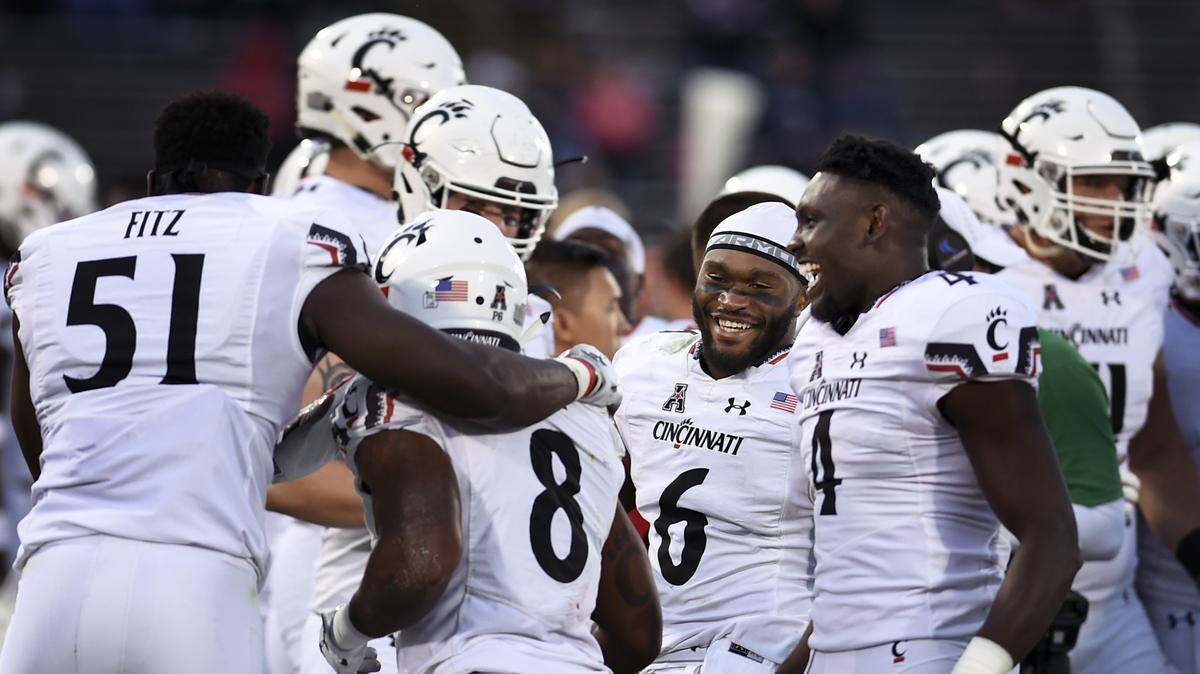 Cincinnati players celebrate on the sidelines after Jarell White (8) intercepted a pass late in the fourth quarter of an NCAA college football game against Connecticut, Saturday, Sept. 29, 2018, in East Hartford, Conn. Cincinnati won, 49-7. (AP Photo/Stephen Dunn)