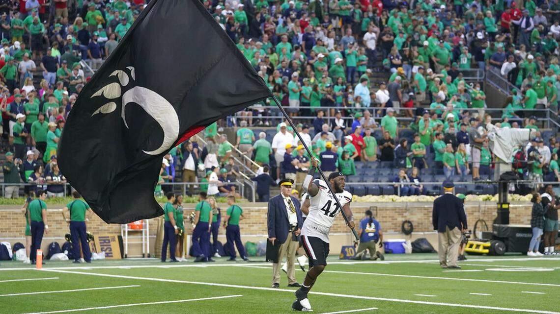 Cincinnati’s Malik Vann (42) runs with the school’s flag after Cincinnati defeated Notre Dame, 24-13, in an NCAA college football game, Saturday, Oct. 2, 2021, in South Bend, Ind. (AP Photo/Darron Cummings)