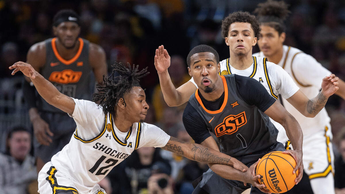 Wichita State’s Melvin Flanagan, left, tries to steal the ball from Oklahoma State’s Bryce Thompson during the first half of their game at Intrust Bank Arena on Saturday night.