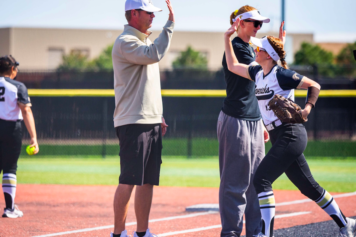 Maize South junior Kinley Davis high fives Maize South softball coach Cody Stucky. Davis scored the winning run in the Mavericks’ dramatic 3-2 win over Topeka Seaman in 17 innings on Thursday at the Class 5A state tournament.