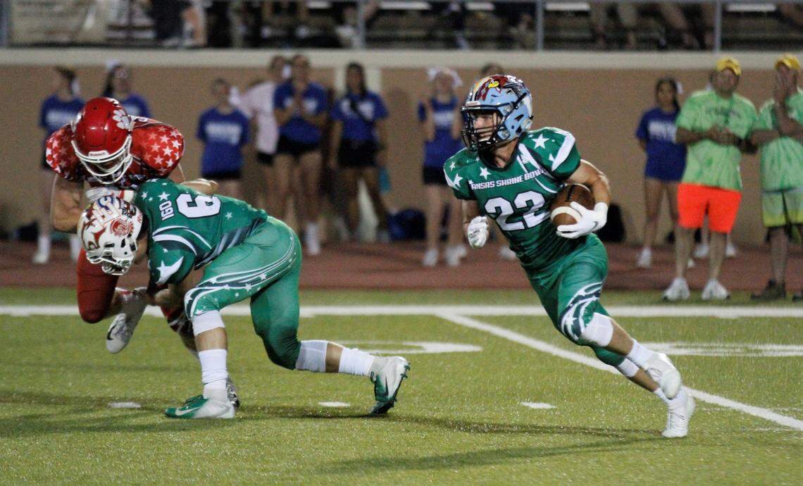 West defensive back Tristan Kulp (Riley County) runs back an interception with Hunter Igo (Derby) lowering a block.