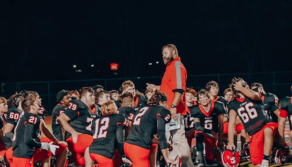 The El Dorado football team listens to coach Wes Bell’s remarks following the program’s first playoff win in school history in a 46-14 win over Winfield last Friday.