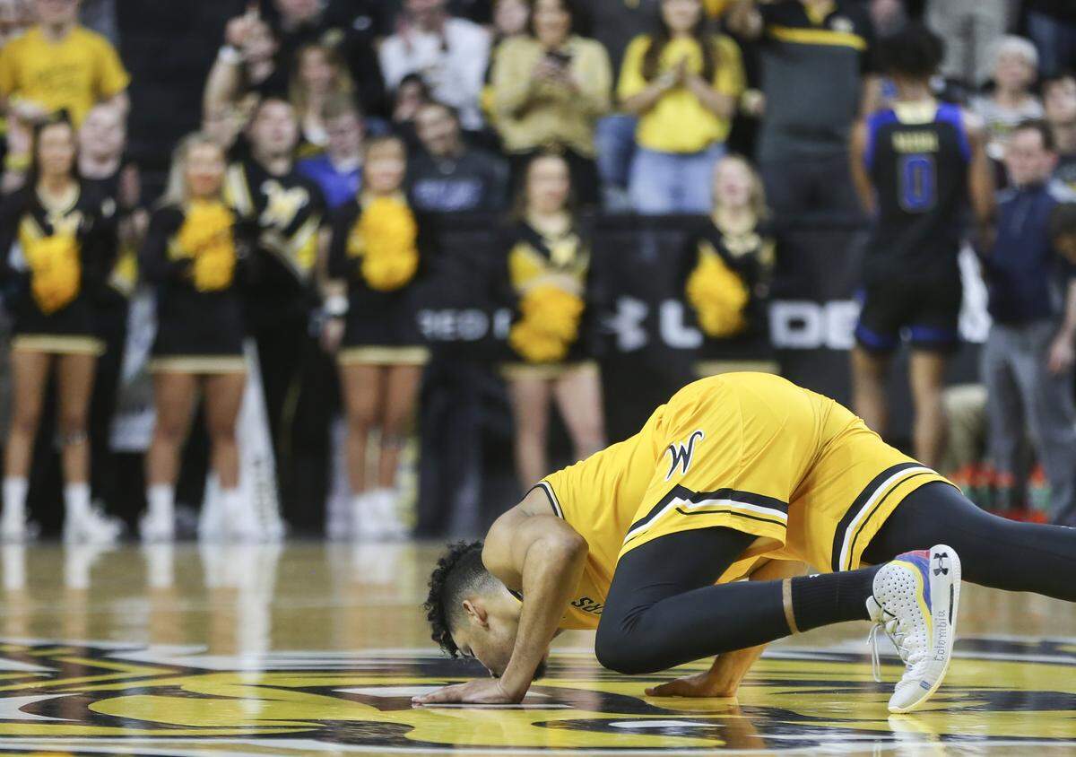 Wichita State senior Jaime Echenique kisses the Koch Arena court after checking out for the final time as a Shocker.
