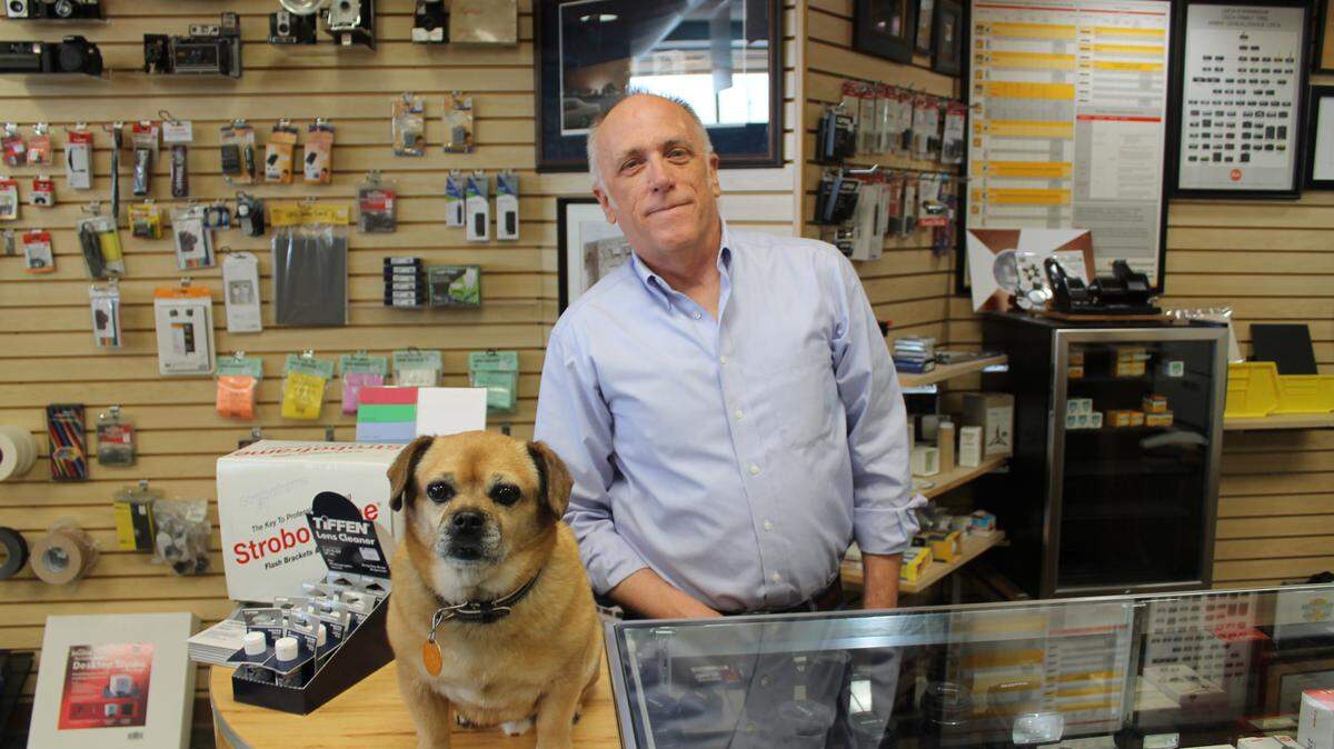 Lawrence Photo Print & Frame owner Paul Hudson, seen here Monday with his dog, Tag, said he'll likely be closing his store at 6508 E. Central in the next 30 days.