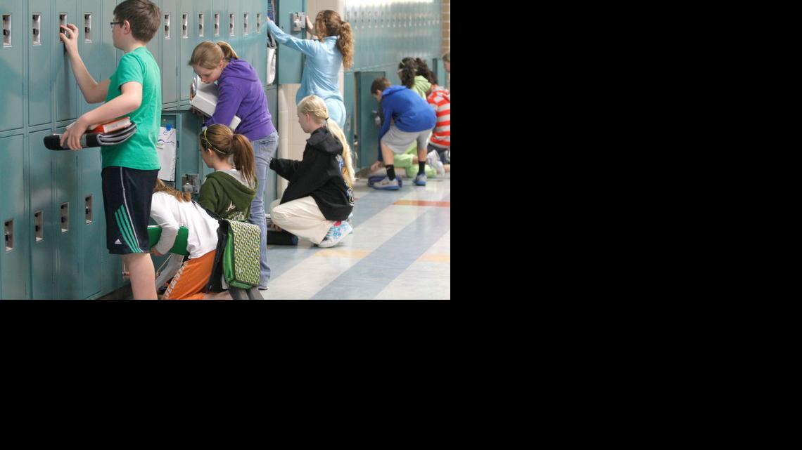 Maize Middle School South students gather their things from their lockers during a passing period.

