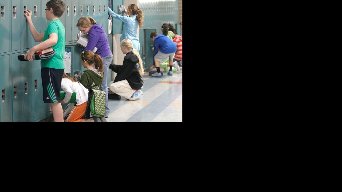 Maize Middle School South students gather their things from their lockers during a passing period.

