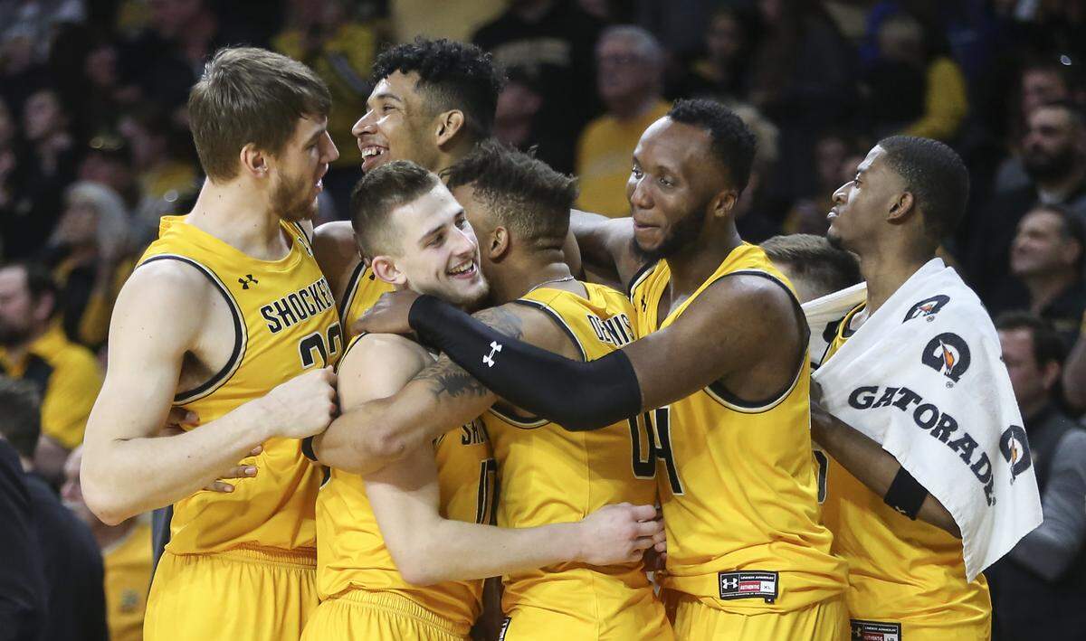 Wichita State players embrace one another after beating Tulsa, 79-57, to close out the regular season.