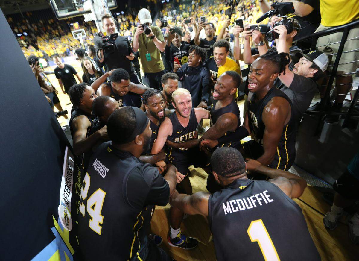 The AfterShocks dance together after winning the regional championship in The Basketball Tournament at Koch Arena in 2022.