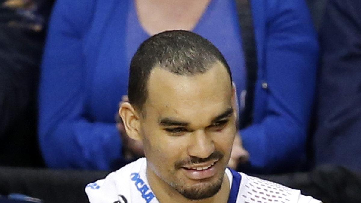 Kansas' Perry Ellis and Joel Embiid cheer from the bench in the final minutes in the second round of the NCAA tournament in St. Louis. (March 21, 2014)