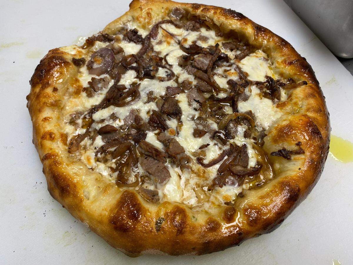 The French Dip pizza on Doo-Dah Diner’s new after-hours to-go menu is served with a side of au jus for dipping.