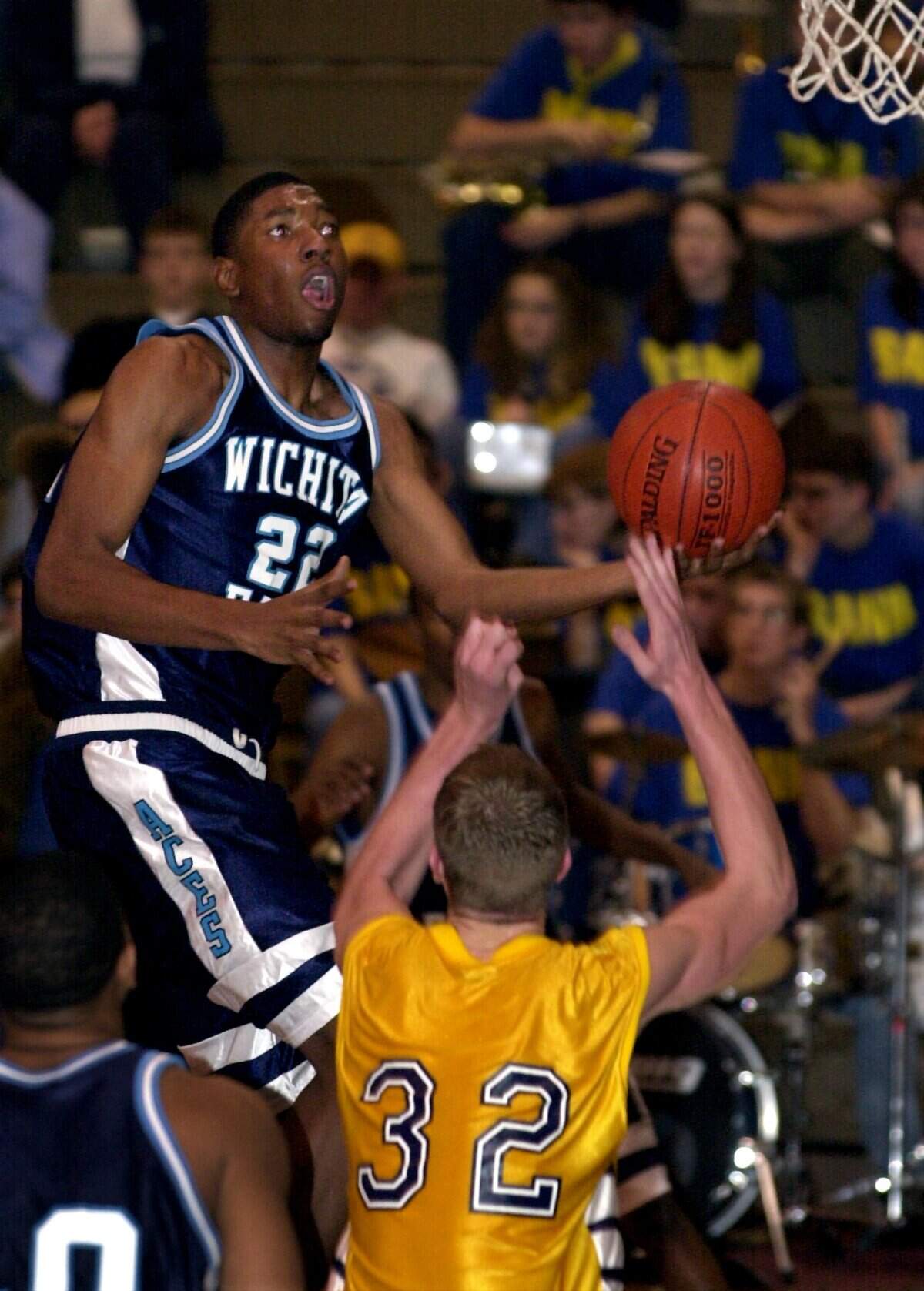 East’s Taj Gray (22) drives past Northwest’s Drew Kanngiesser (32) for two points in a game at Northwest.