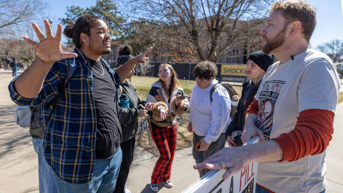 Russell Hunter, right, part of a large group of anti-abortion protesters who went to Wichita State’s campus on Friday, has a lively debate with a student who didn’t want to provide their name. A large number of out-of-state anti-abortion activists have come to Wichita this week and have appeared at several locations, including area high schools and college campuses on Friday.