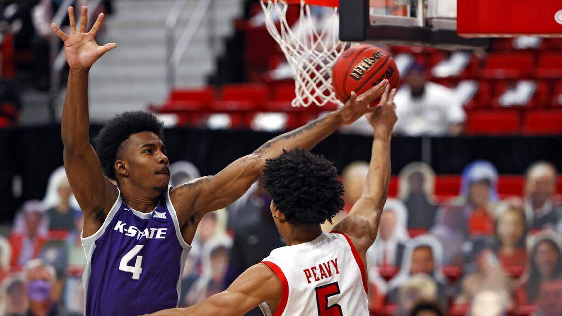 Texas Tech’s Micah Peavy (5) passes the ball around Kansas State’s Seryee Lewis (4) during the first half of an NCAA college basketball game Tuesday, Jan. 5, 2021, in Lubbock, Texas. (AP Photo/Brad Tollefson)