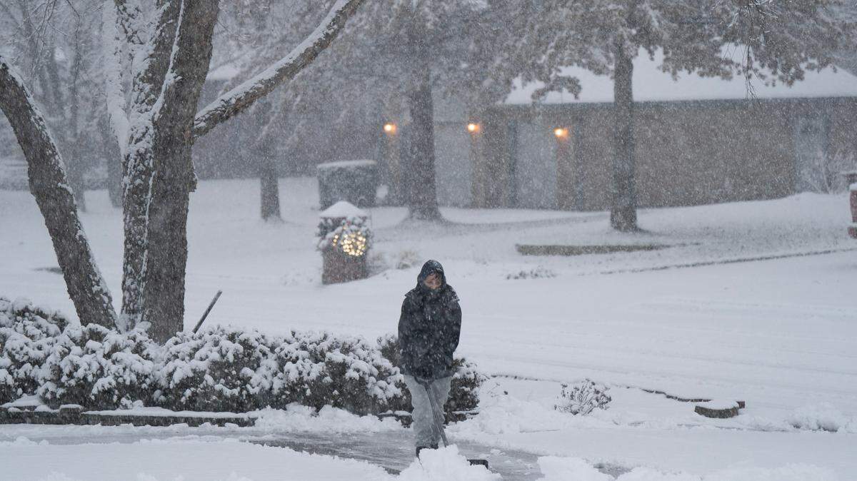 Jacy Barker clears the driveway of her west Wichita home early Friday morning. The area could see chilling temperatures later this week thanks to an arctic air mass.