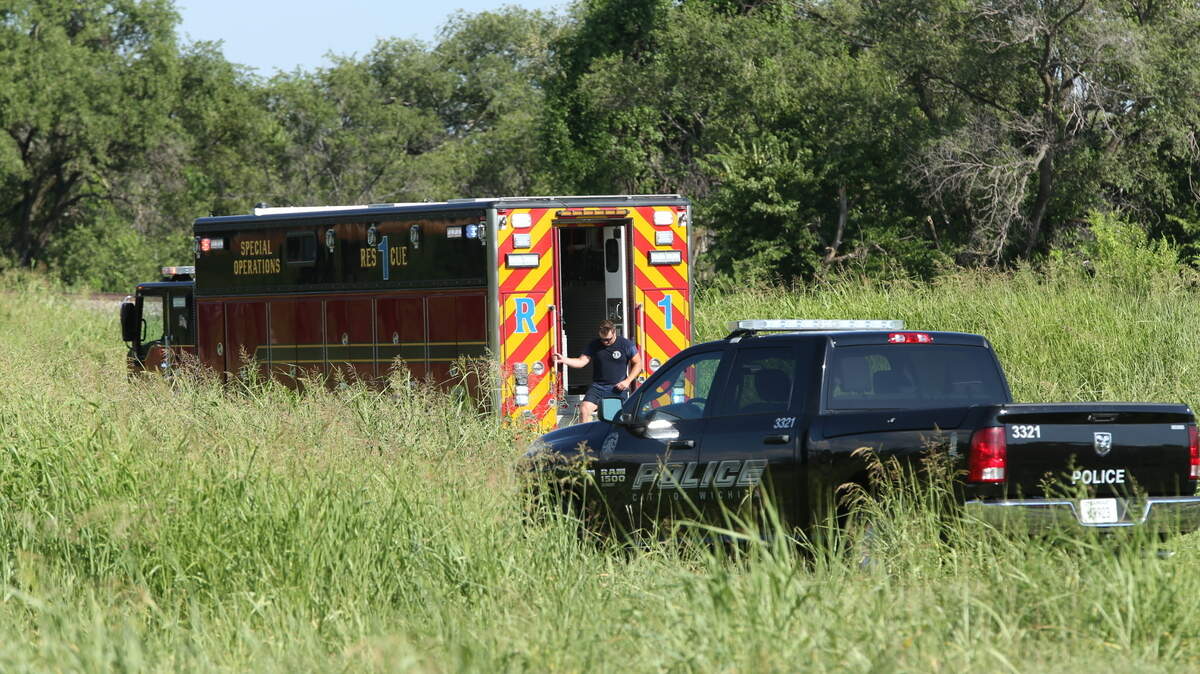 A Wichita firefighter exits a rescue truck parked near the Arkansas River in south Wichita. Authorities pulled a man’s body out of the water Thursday afternoon.