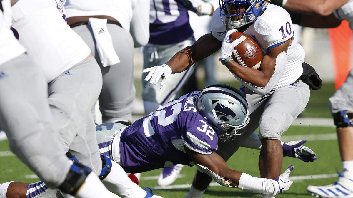 Kansas State linebacker Justin Hughes (32) grabs Kansas running back Khalil Herbert (10) near the line of scrimmage at Snyder Family Stadium in Manhattan. (Bo Rader/Wichita Eagle)