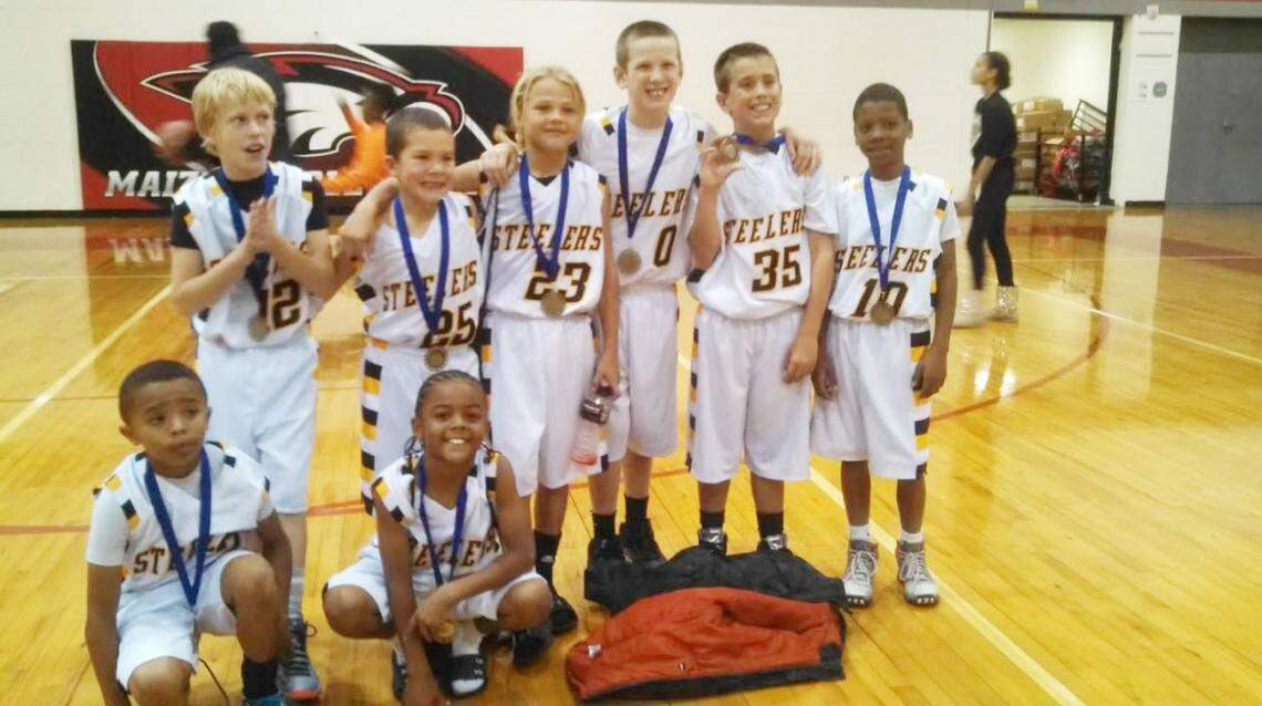 A young Avery Johnson (No. 23) poses for a picture with WIll Anciaux (0) and other teammates after winning a basketball tournament with the Wichita Steelers.