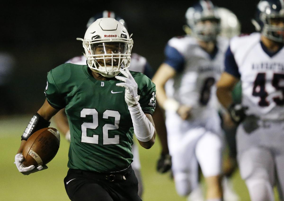 Derby running back #22 Tre Washington leads a pack of Manhattan defenders down field as he runs for a touchdown in opening minutes Friday night. (November 16, 2018)