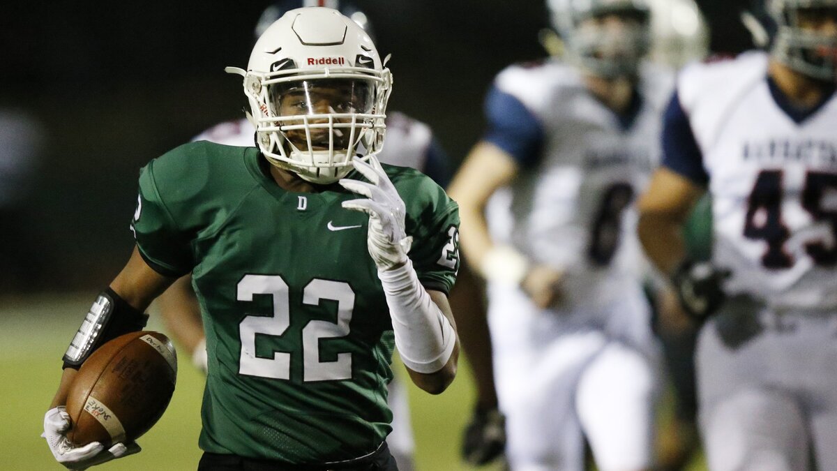 Derby running back #22 Tre Washington leads a pack of Manhattan defenders down field as he runs for a touchdown in opening minutes Friday night.  (November 16, 2018)