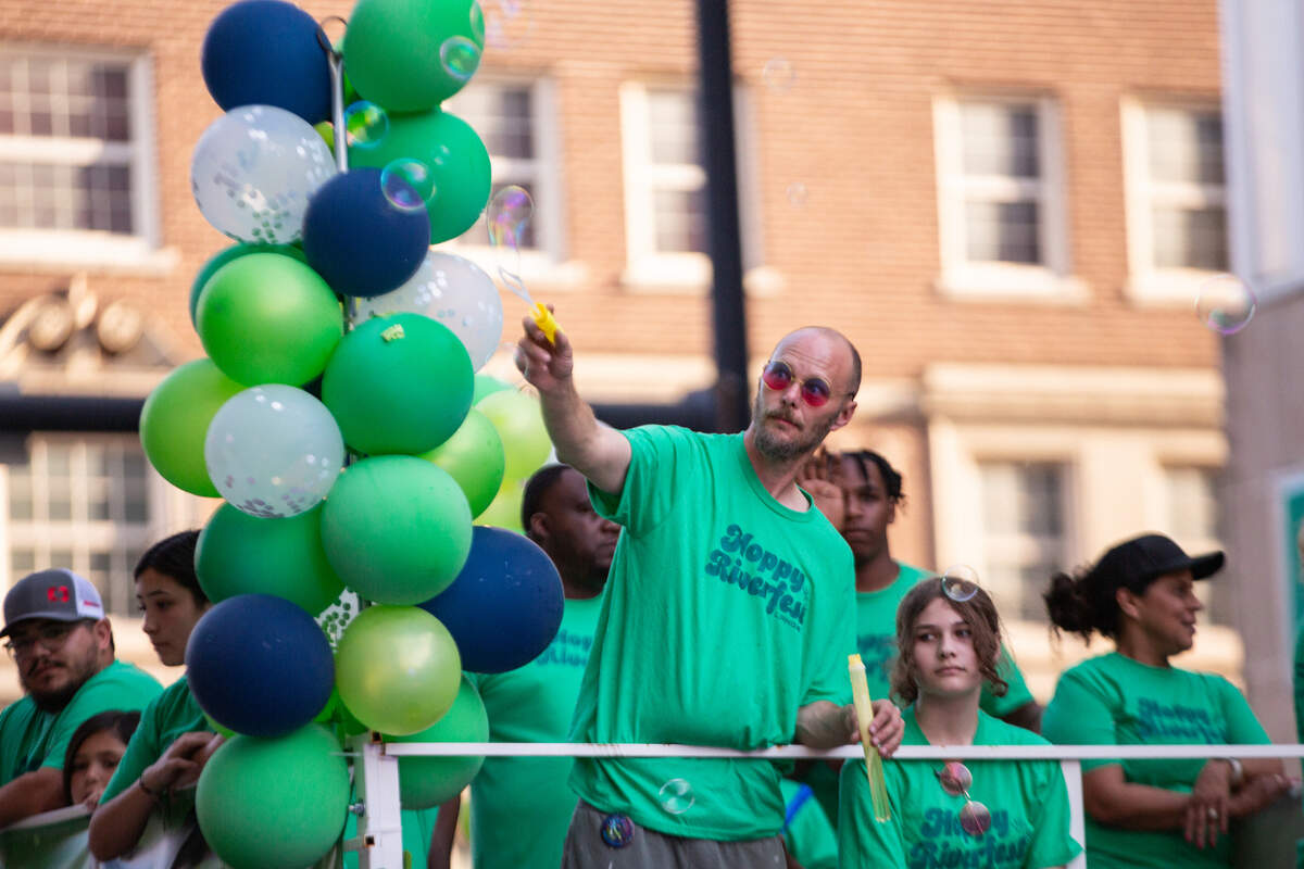 Shane Gerber, senior director of finance at Lange Real Estate, creates bubbles at the Star Lumber Sundown Parade on Friday.