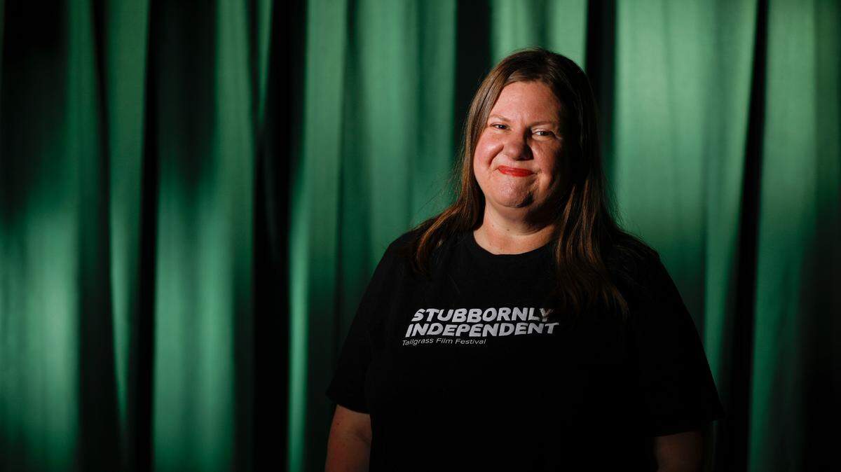 Tallgrass Film Association executive director Melanie Addington stands before a curtain at the Lux at First and Market where the organization will have an office, workshops and pop-up films.