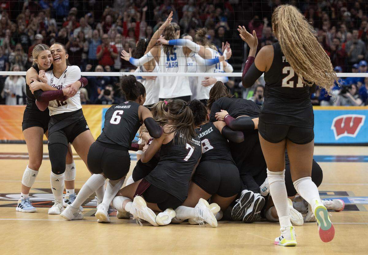 Texas A&M players celebrate finishing a sweep of Kentucky in the championship match of the NCAA Volleyball Championship on Sunday afternoon at the T-Mobile Center.