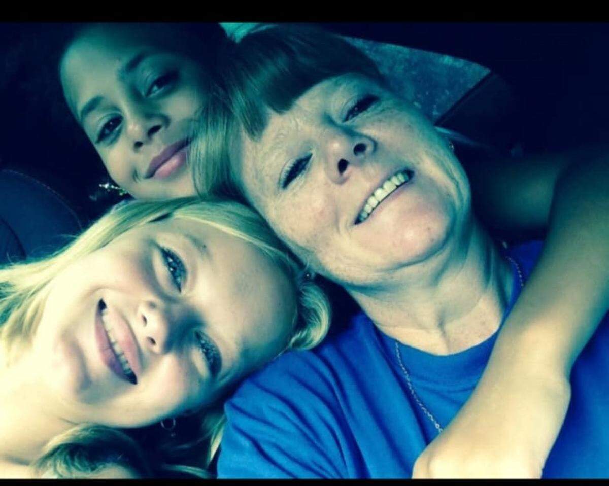 Naomi Oglesby puts her arm around her mother, Shaila Canoot, during a childhood photo alongside her sister, Christina Pape.