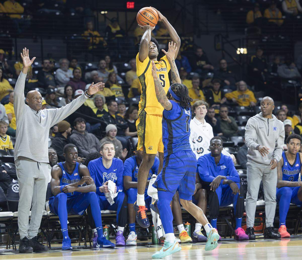 Wichita State’s Brian Amuneke hits a 3-pointer in front of the Memphis bench during the first half at Koch Arena.