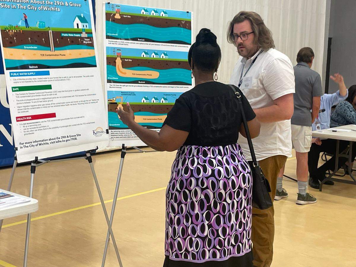 A representative from the Kansas Department of Health and Environment talks to a resident at a community meeting about the 29th and Grove contamination site held June 24 at the Boys and Girls Club.