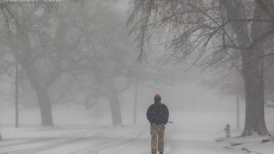 James Bryson walks through Wichita’s Riverside neighborhood on his way to work as snow pours down Thursday morning.