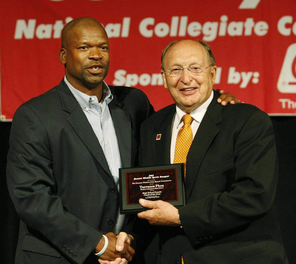 Collegiate girls basketball coach Terrence Phox, left, receives the award for Coach of the Year from Sports Commission CEO Bob Hanson during the Greater Wichita Sports Banquet at the Hyatt Thursday. (June 30, 2011)