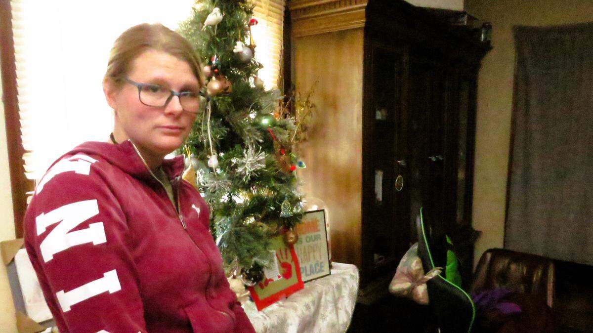 Amber Huffman in front of her family’s Christmas tree. The tree isn’t lit because there’s no electricity to the home, after the landlord died and his heirs had the city of Stafford shut the power off.