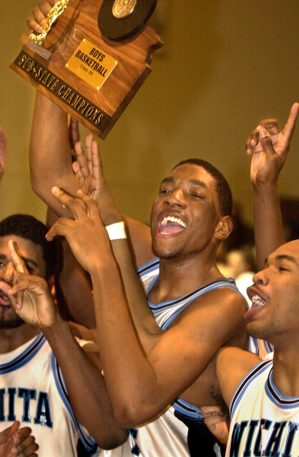 Taj Gray and the rest of the East High basketball team celebrate after being crowned sub-state champions.