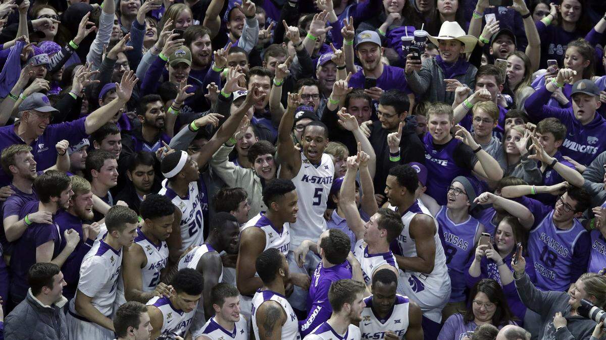 Kansas State players, including Barry Brown (center), celebrated with fans following a win over Oklahoma in Manhattan Kan., last season.
