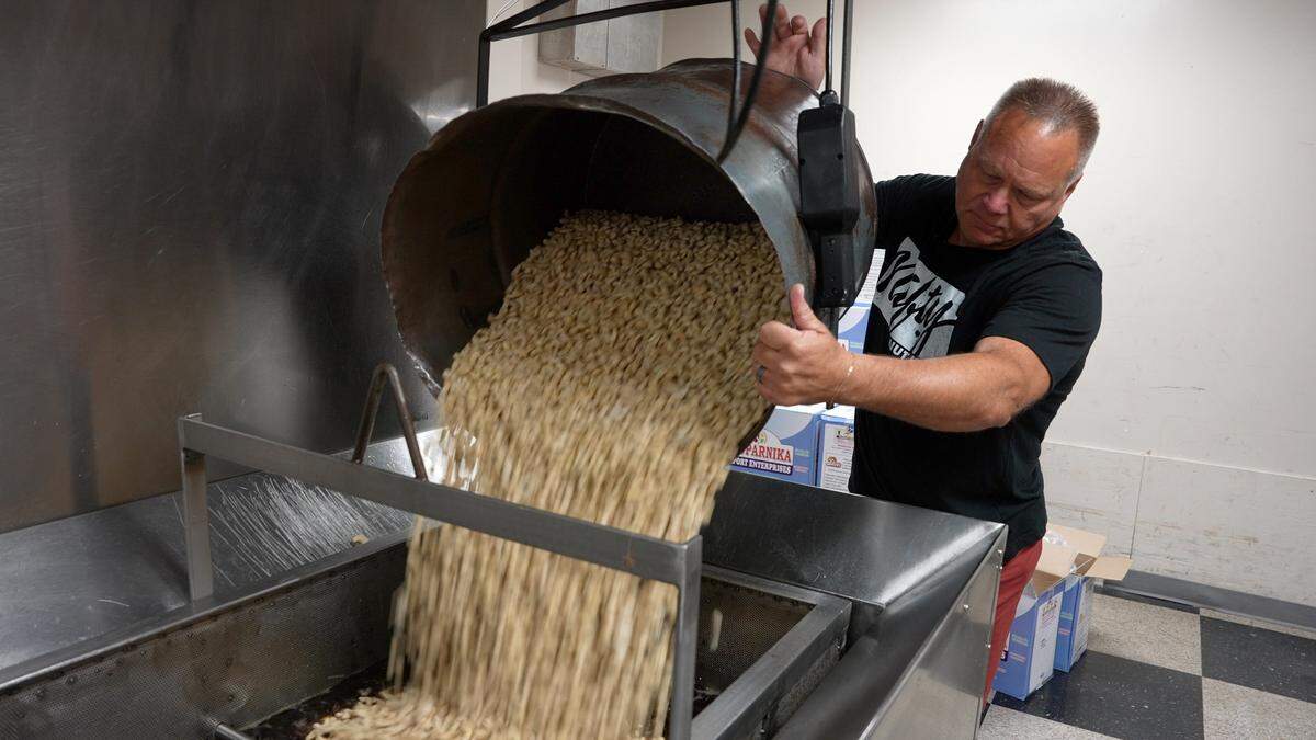Nifty Nuthouse owner Steve Jahn dumps 150 pounds of raw cashews into the roaster.