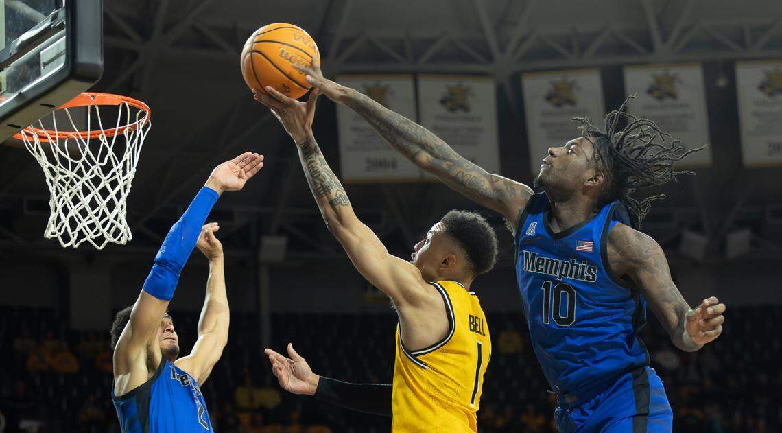 Wichita State’s Xavier Bell goes up a for a shot against Memphis defenders Jaykwon Walton, right, and Nicholas Jourdain, left, during the first half on Sunday.