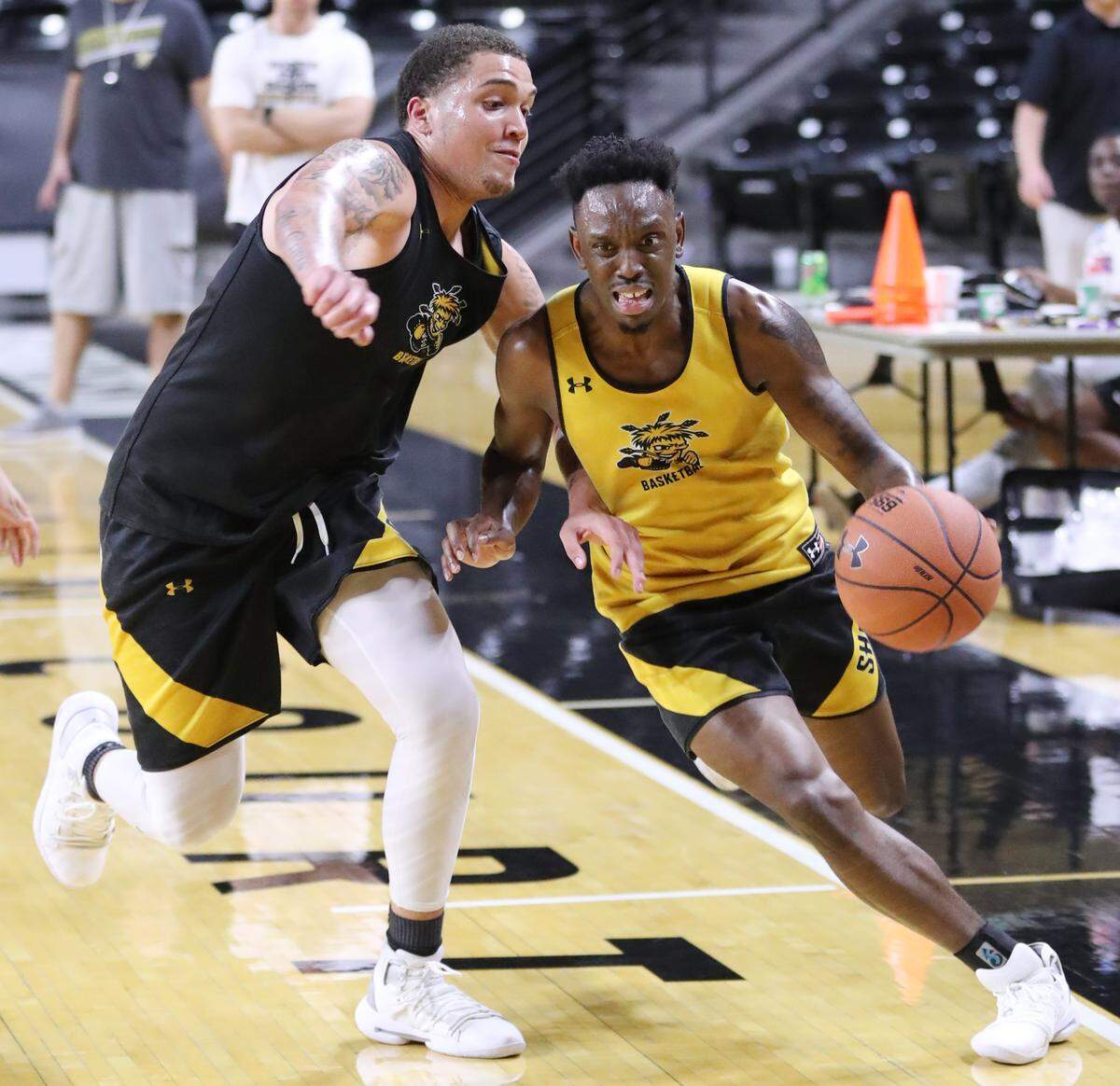 Samajae Haynes-Jones (yellow) drives past Teddy Allen (black) in a drill during Wichita State’s first practice of the season on Tuesday at Koch Arena.