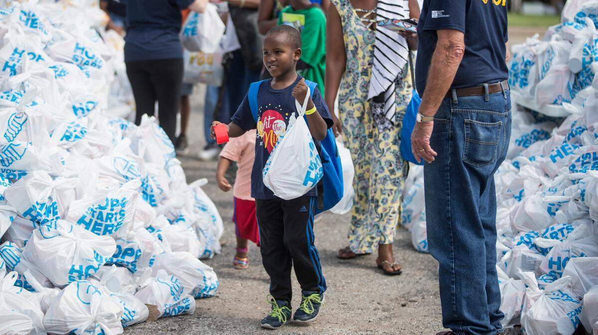 Kelly Micomyiza, 7, receives food during the annual Convoy of Hope event at McAdams Park on Saturday. 