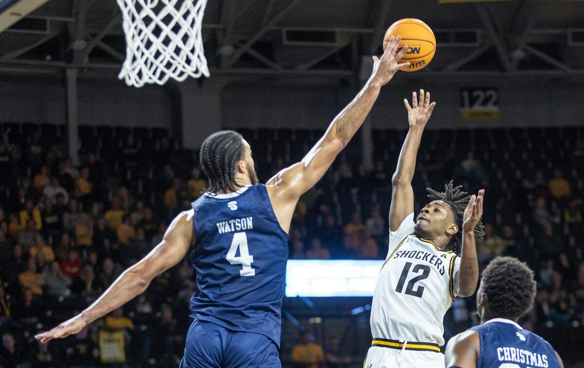 WIchita State’s Melvin Flanagan puts up a floater over Longwood’s Zac Watson to end the first half of their game on Saturday at Koch Arena.