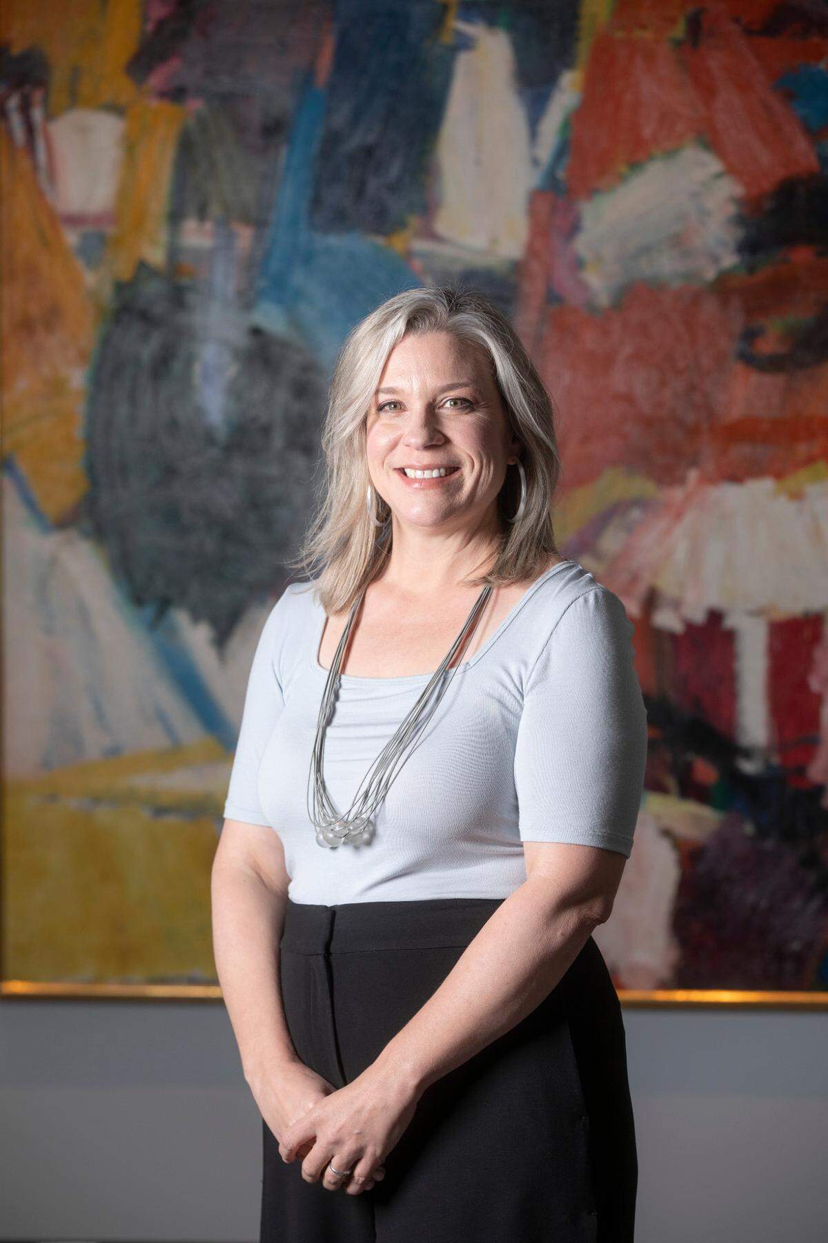 Anne Kraybill is the new director of the Wichita Art Museum. Kraybill is standing in front of Grace Hartigan’s 1957 oil painting “East River Drive.”