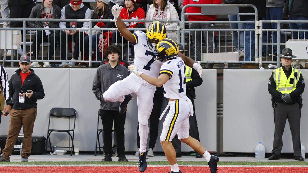 Michigan running back Donovan Edwards, left, celebrates his touchdown against Ohio State with teammate Roman Wilson during the second half of an NCAA college football game on Saturday, Nov. 26, 2022, in Columbus, Ohio. (AP Photo/Jay LaPrete)