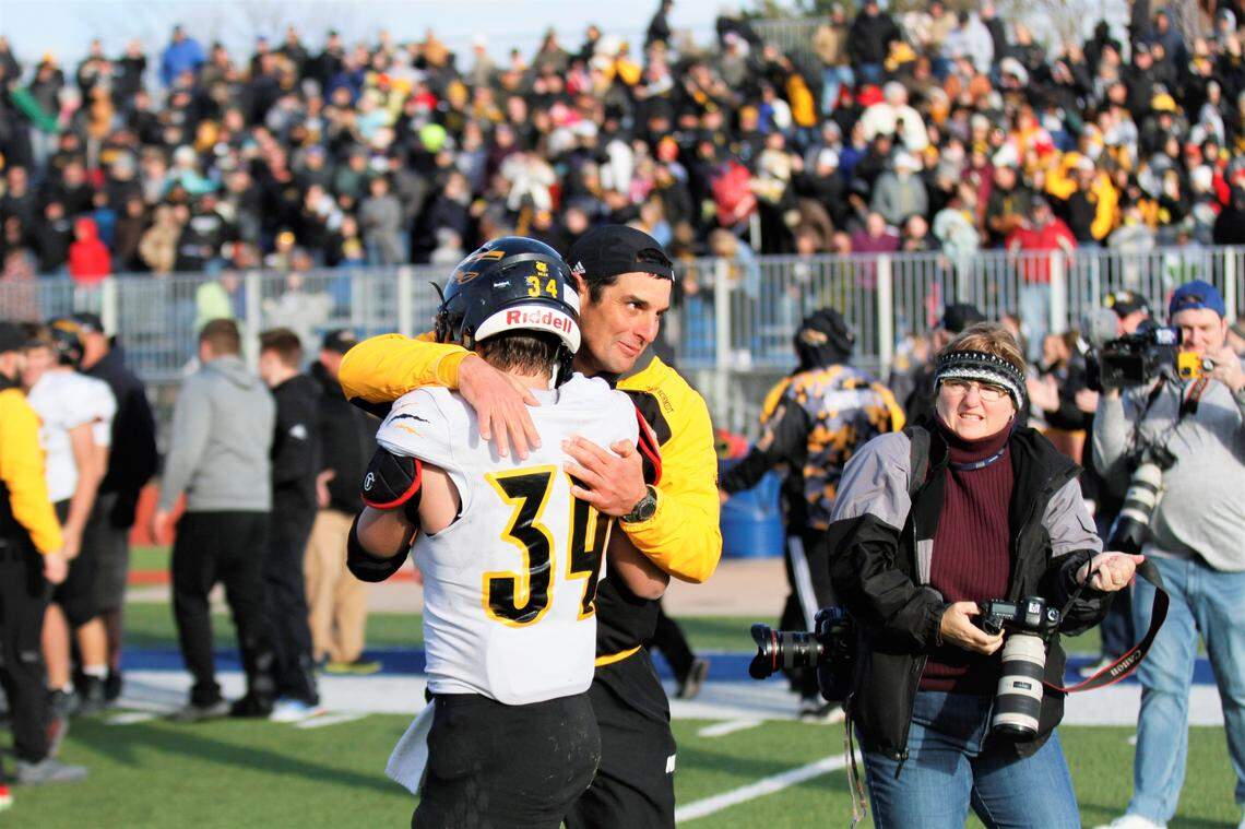 Andale coach Dylan Schmidt hugs senior Mac Brand after beating Perry-Lecompton 35-7 to clinch his first state title as a coach.