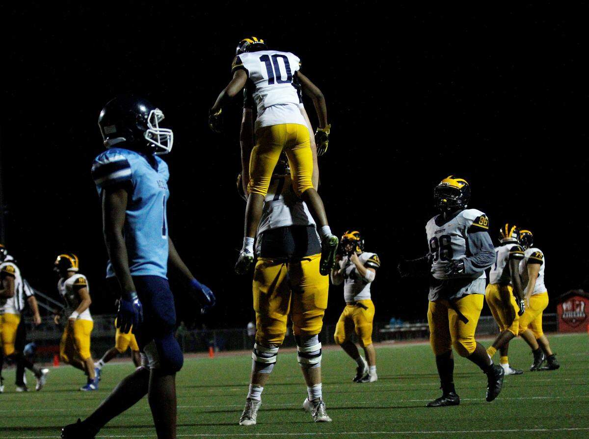 Wichita Northwest senior lineman Joey Duncan hoists senior receiver Jamir Cupps after a touchdown in the Grizzlies’ 56-0 win over the Blue Aces on Thursday night. (Sept. 6, 2018)