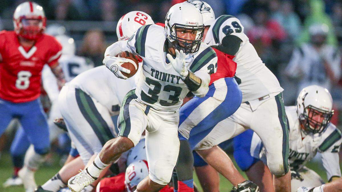 Trinity’s Tyler Burns runs for yardage against Cheney in the first quarter at Cheney High Friday night. (Oct. 3, 2014)