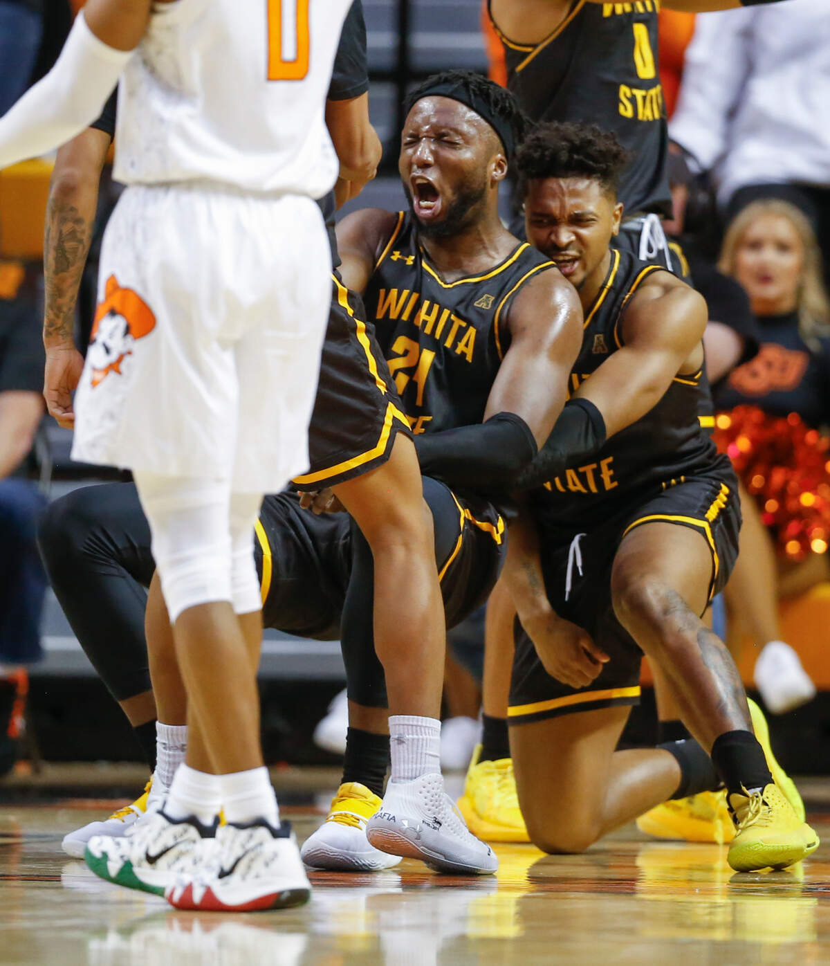 Wichita State’s Tyson Etienne picks up teammate Morris Udeze after Udeze picked up a charge call in the second half against Oklahoma State.