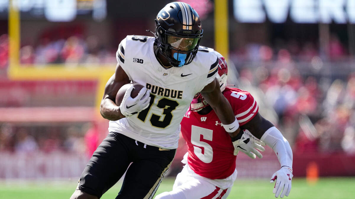 Purdue Boilermakers wide receiver Jaron Tibbs (13) rushes with the football in front of Wisconsin Badgers cornerback RJ Delancy III (5) during the second quarter at Camp Randall Stadium.