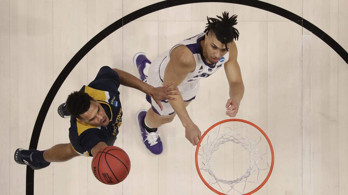 UC Irvine guard Evan Leonard, left, shoots against Kansas State guard Mike McGuirl during the first half of a first round men’s college basketball game in the NCAA Tournament Friday, March 22, 2019, in San Jose, Calif. (AP Photo/Ben Margot)