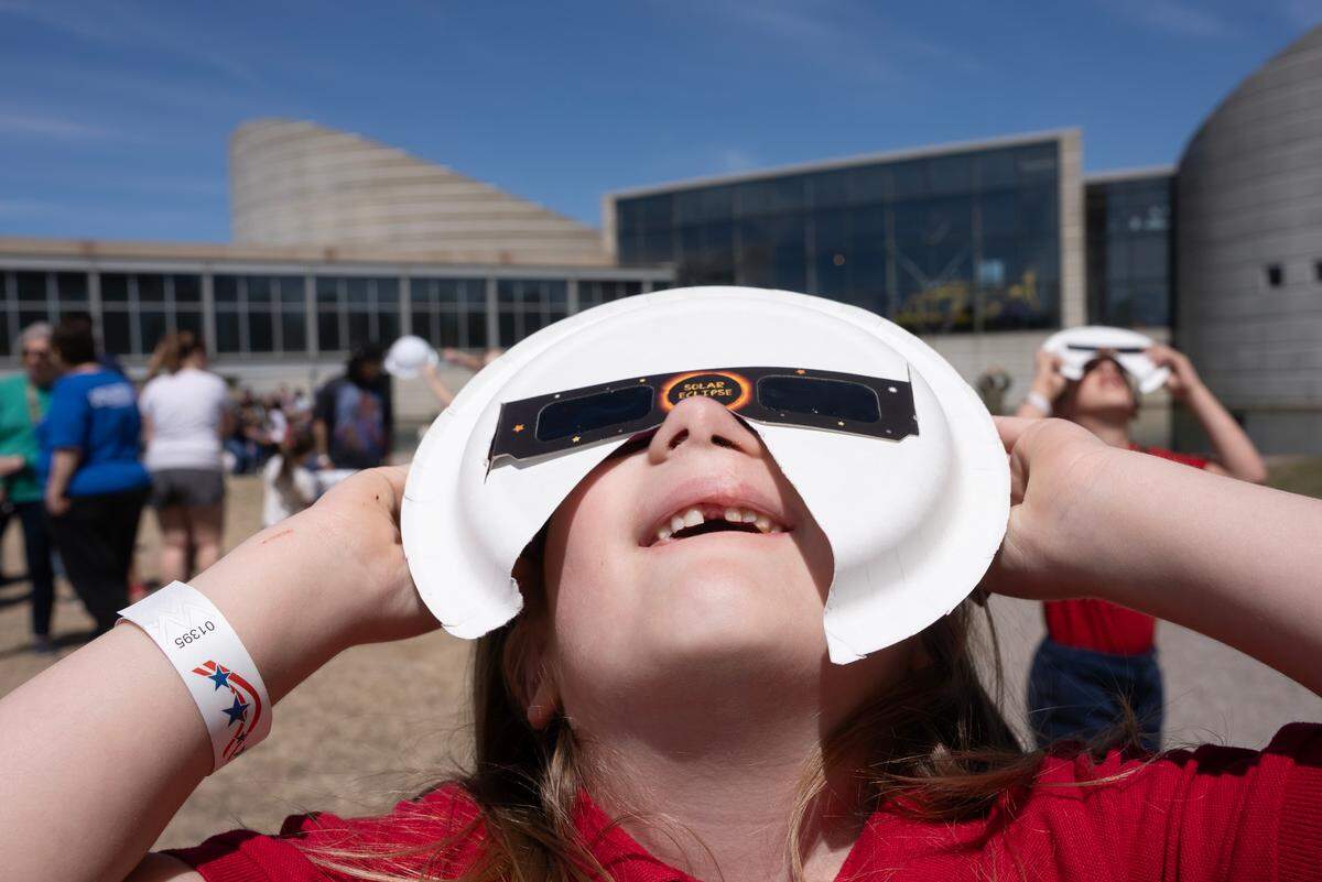 Selena Steele Denny watches the eclipse at Exploration Place on Monday.