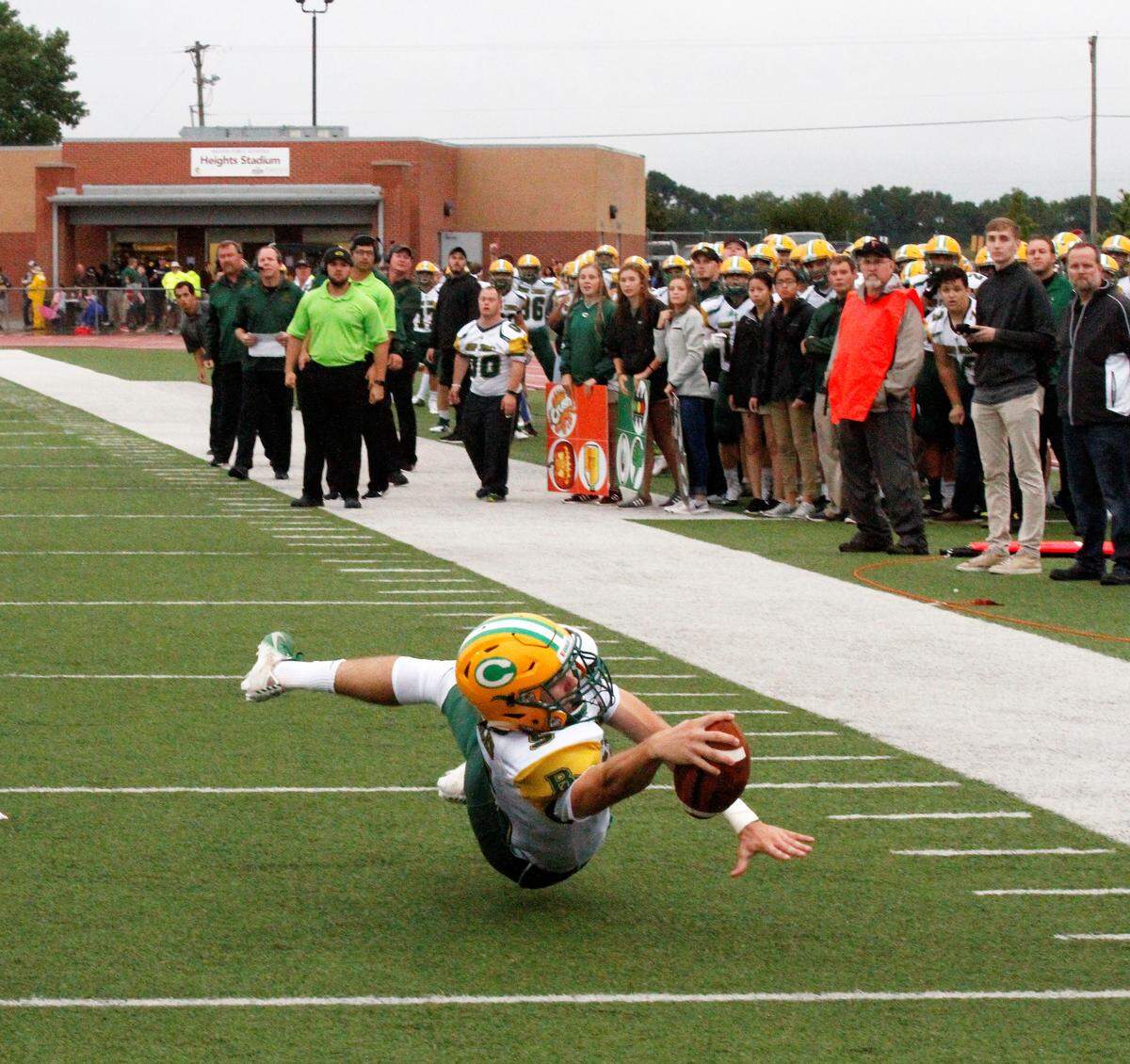 Cade Becker, a Bishop Carroll senior quarterback, reaches for the goal line against Wichita Heights in the Golden Eagles’ 36-20 win over the Falcons on Friday. (Sept. 7, 2018)